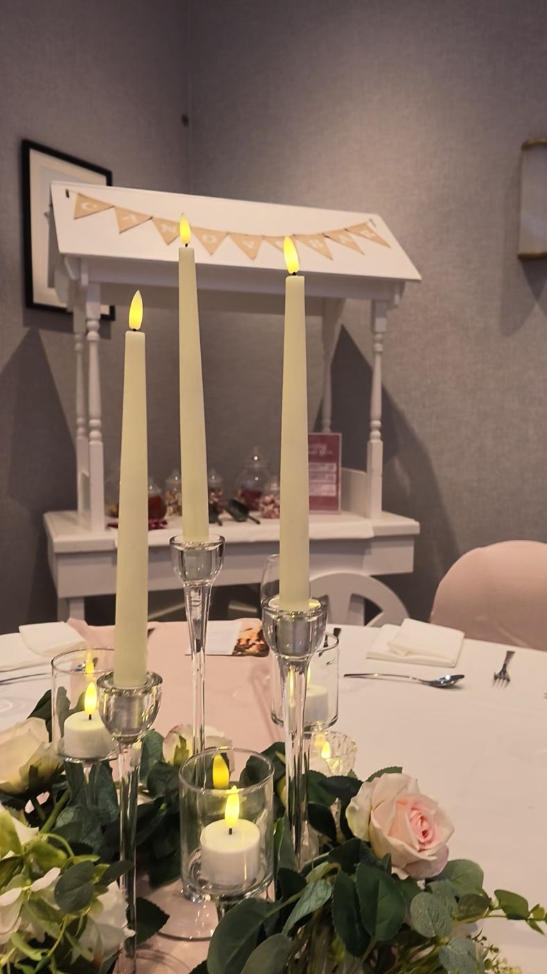 Taper candles glowing on a reception table