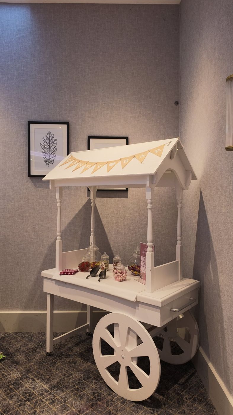 White sweet cart with bunting and jars of sweets