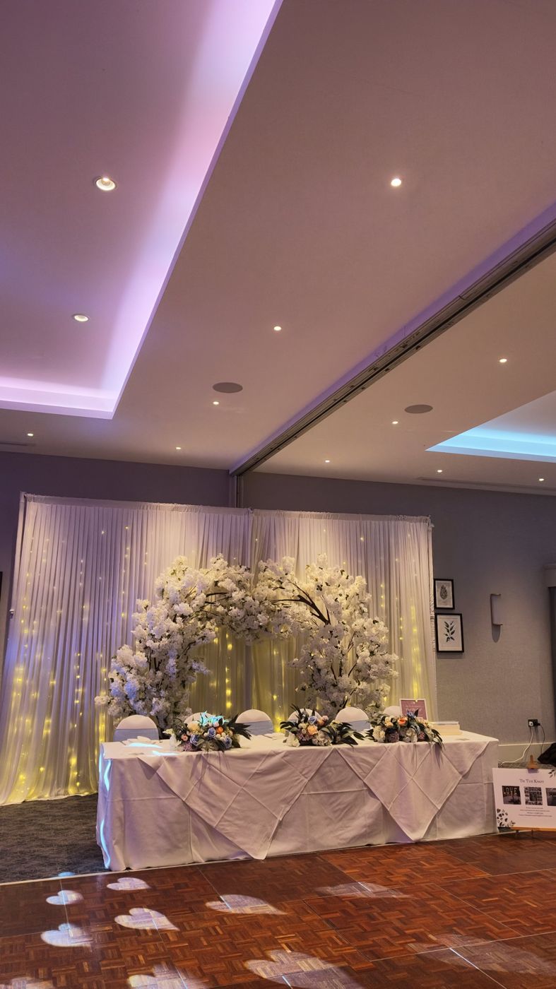 Blossom arch and draped top table at a wedding reception